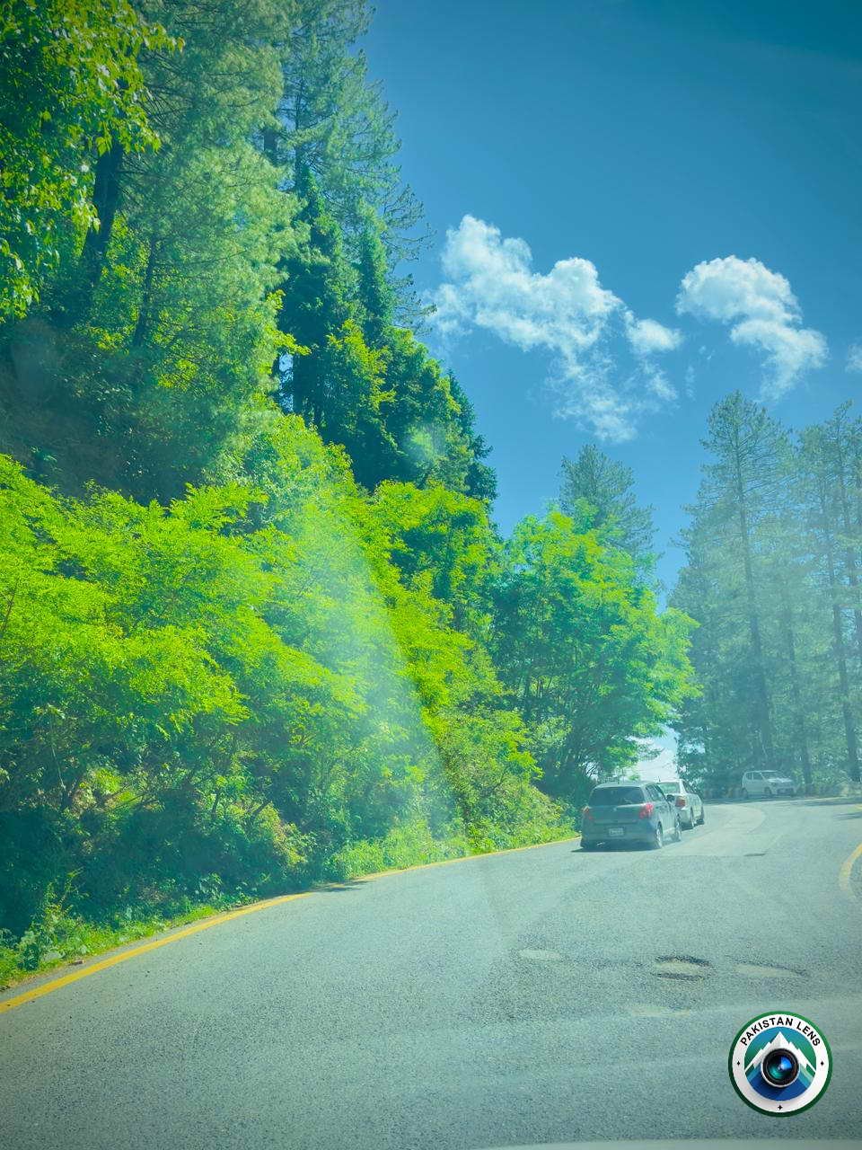 
 Forest road surrounded by lush green mountains in Galiyat Abbottabad Pakistan